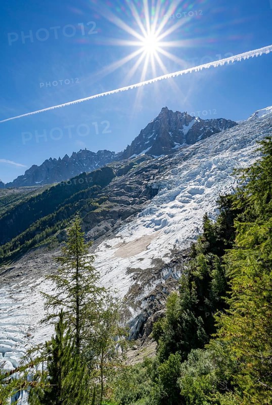 View of glacier Glacier des Bossons with sun star, behind summit of Aiguille du Midi, Chamonix, Haute-Savoie, France, Europe