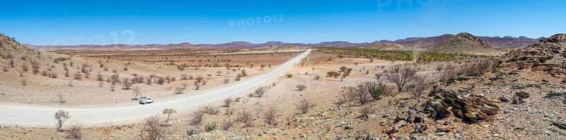 Panorama, gravel track leads through barren dry landscape with hills, Damaraland, Kunene, Namibia, Africa