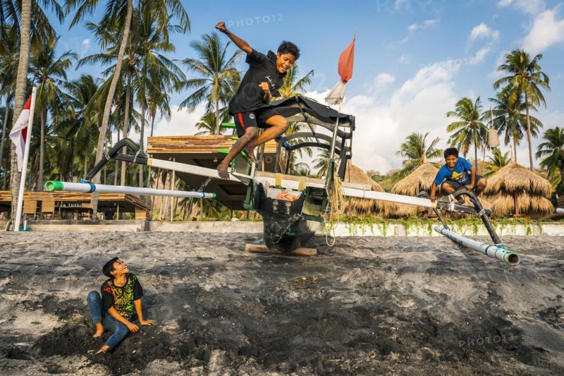 Jumping children in the evening sun at Mangsit beach in Sengiggi, travel, tourism, sea, beach, water, fun, joy, childhood, emotion, play, freedom, happiness, happy, carefree, light-heartedness, childlike, joie de vivre, friendship, friends, ocean, island, coast, tropical, tropics, Asian, authentic, authenticity, original, atmosphere, holiday mood, long-distance travel, tradition, traditional, poverty, culture, tradition, holiday idyll, Lombok, Indonesia, Asia