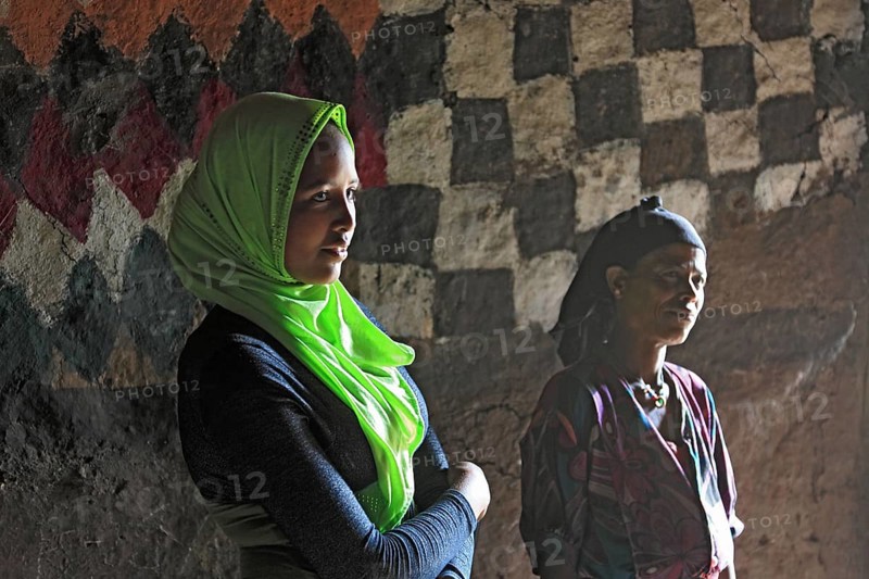 Mother and daughter with headscarf in their round hut in the south of the country, Ethiopia, Africa