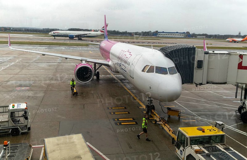Wizz Air Airbus A320 plane at south terminal, London Gatwick airport, England, UK viewed through glass window with some reflections