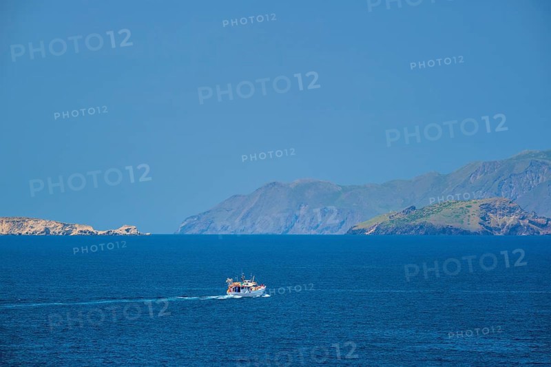 Greek fishing boat in blue waters of Aegean sea near Milos island, Greece, Europe