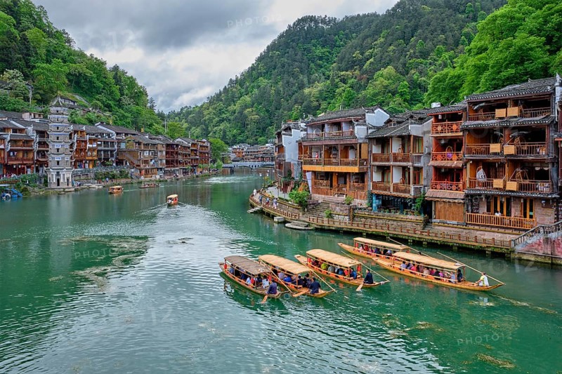 Chinese tourist attraction destination, Feng Huang Ancient Town (Phoenix Ancient Town) on Tuo Jiang River with Wanming Pagoda tower and tourist boats. Hunan Province, China, Asia