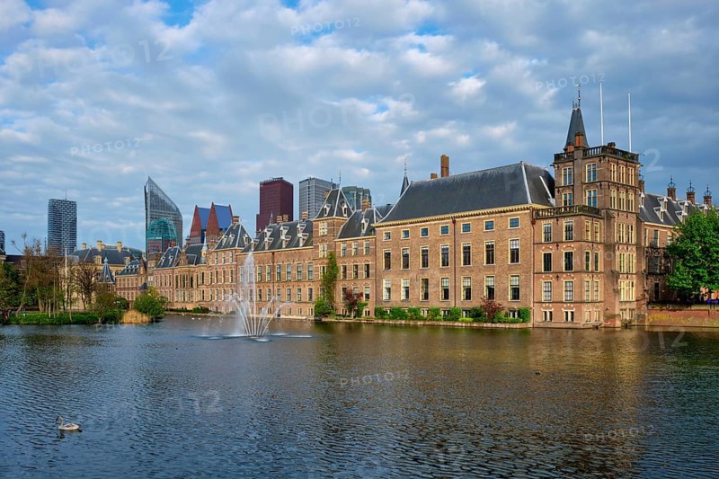 View of the Binnenhof House of Parliament and the Hofvijver lake with downtown skyscrapers in background. The Hague, Netherlands