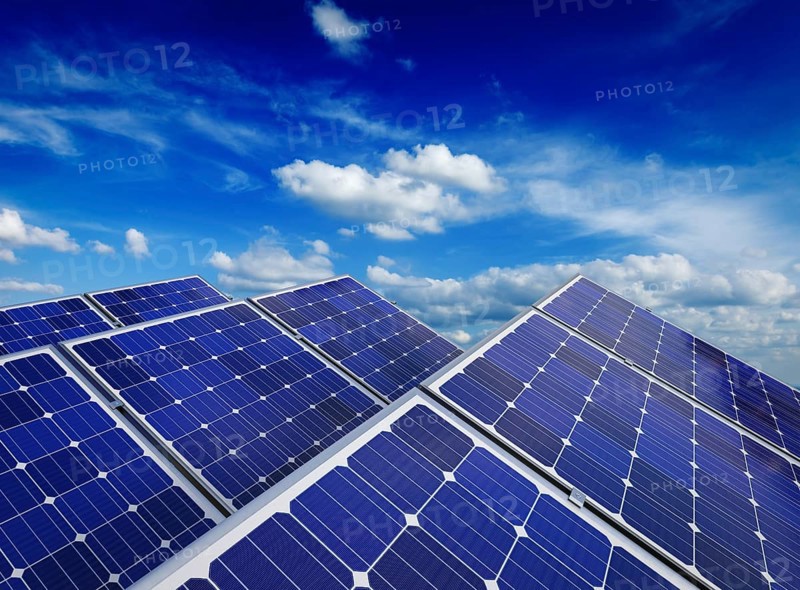 Solar power generation technology, alternative renewable energy and environment protection ecology concept, close up of solar battery panels against blue sky with clouds