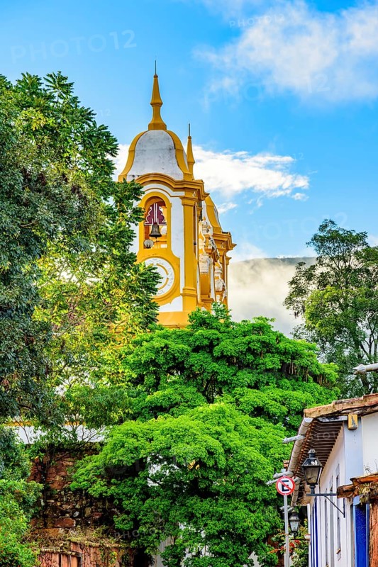Baroque church tower rising through vegetation and buildings in the city of Tiradentes in the state of Minas Gerais, Brasil