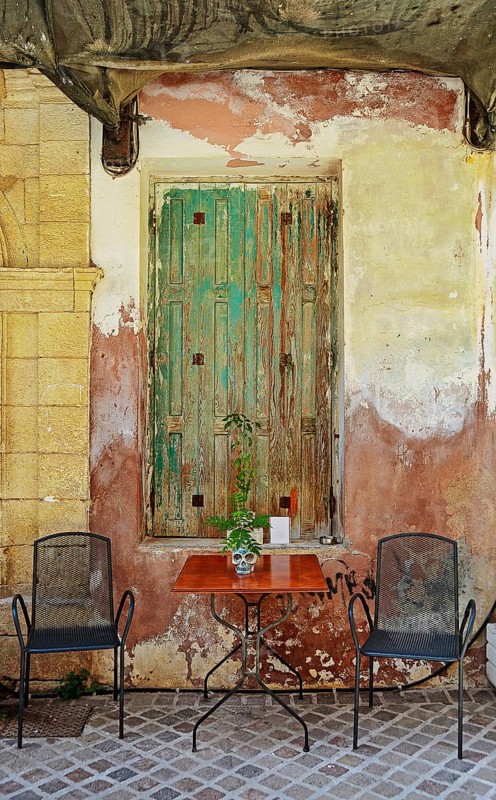 Table and chairs, seat in front of old door, Chania, Crete, Greece, Europe