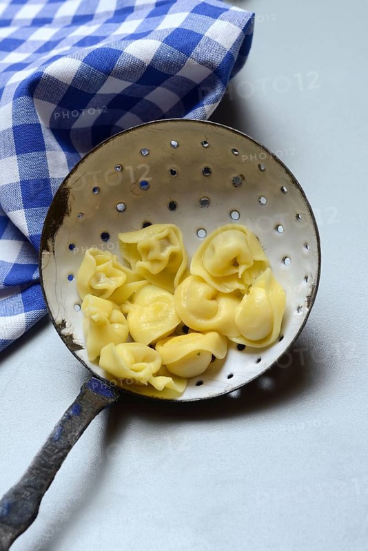 Cappelletti, cooked pasta in a sieve ladle, pasta