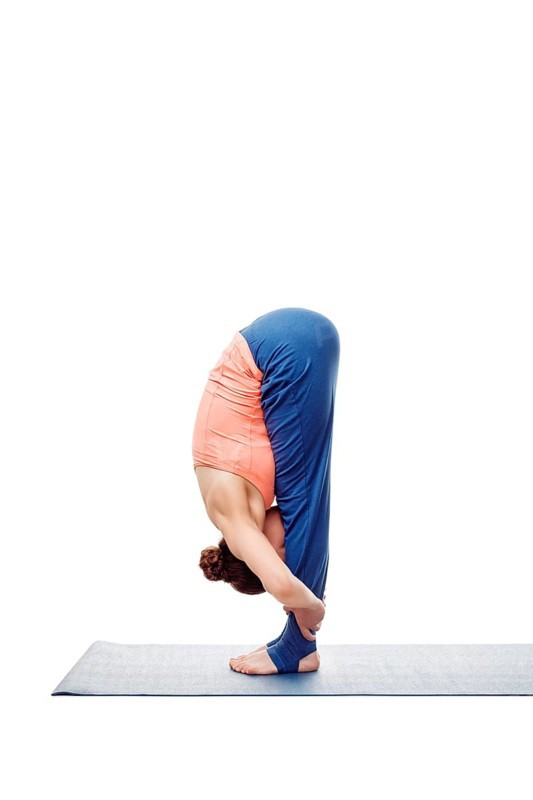 Woman doing Ashtanga Vinyasa Yoga Surya Namaskar Sun Salutation asana uttanasana, standing forward bend pose posture isolated on white background