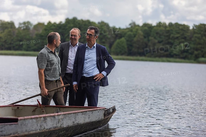 Federal Minister of Food and Agriculture, Cem Özdemir, visits the Karsten Ringpfeil pond farm in Königswartha together with Saxony's Minister of Agriculture, Wolfram Günther. The gentlemen are standing on a barge used to spread the feed