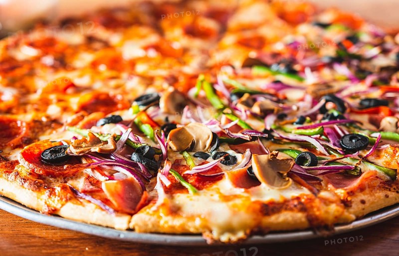 Close up of supreme pizza with olives on wooden table. Delicious Supreme Pizza and pepperoni on wood with copy space