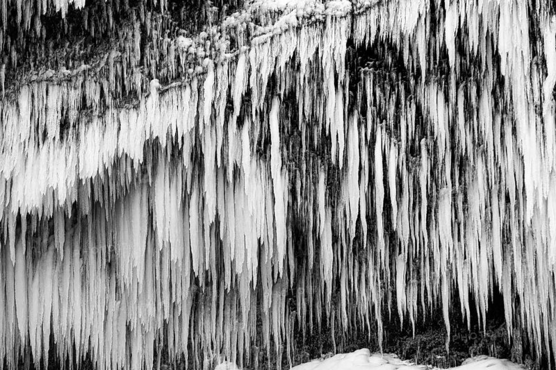 Icicles on the rock face at Skogafoss waterfall, black and white photo, Sudurland, Iceland, Europe