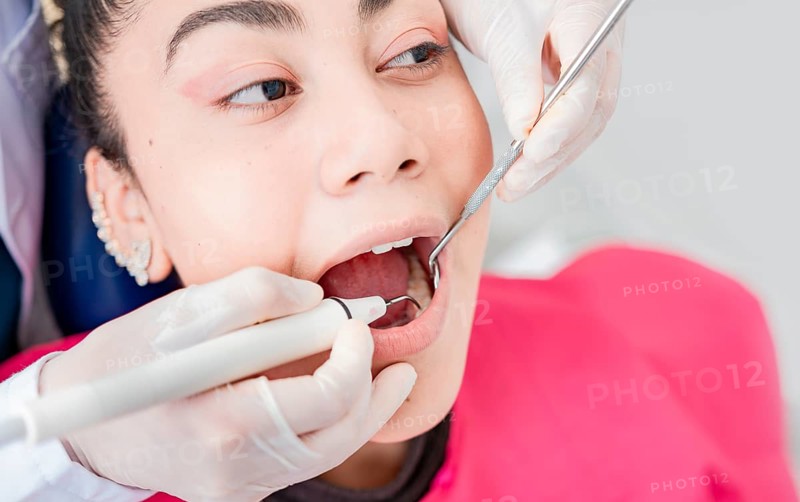 Close up of dentist checking patient with excavator and dental mirror, Dentist checking patient with excavator and dental mirror, Patient checked by dentist, Dentist doing dental checkup
