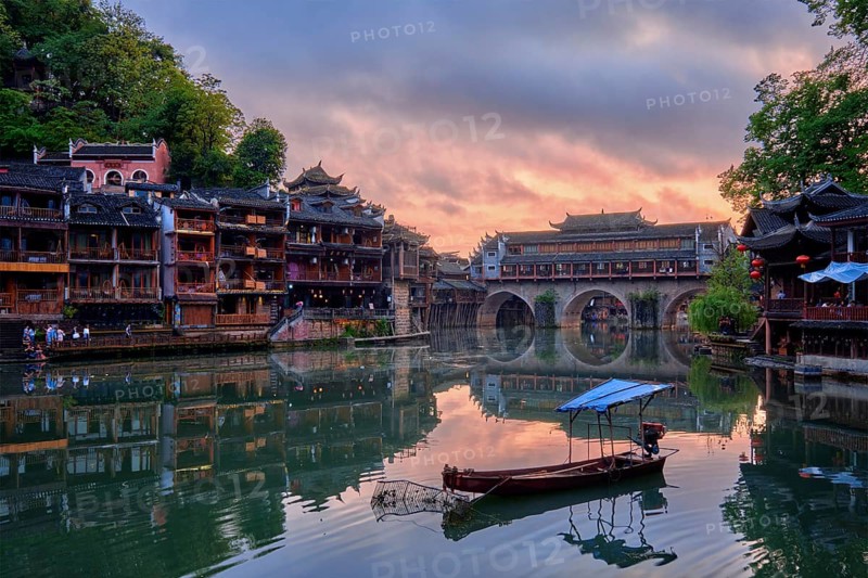 Chinese tourist attraction destination, Feng Huang Ancient Town (Phoenix Ancient Town) on Tuo Jiang River illuminated at night. Hunan Province, China, Asia
