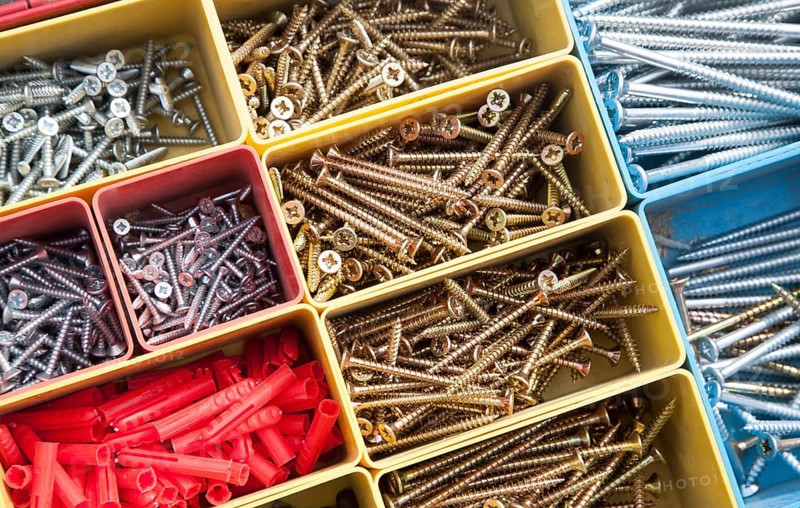 Colourful carpentry box of metal screws viewed from above