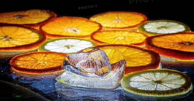 Transparent slices of fresh oranges and lemons on the glass with ice
