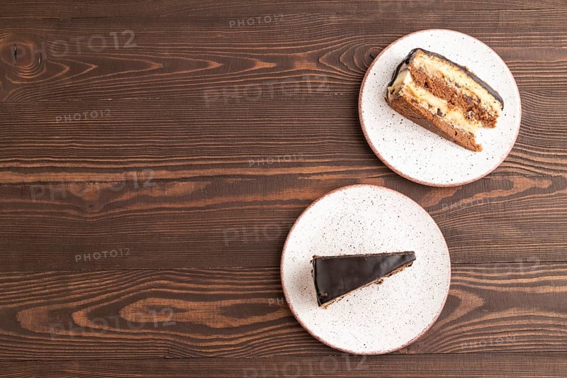 Chocolate biscuit cake with caramel cream on brown wooden background. top view, flat lay, copy space