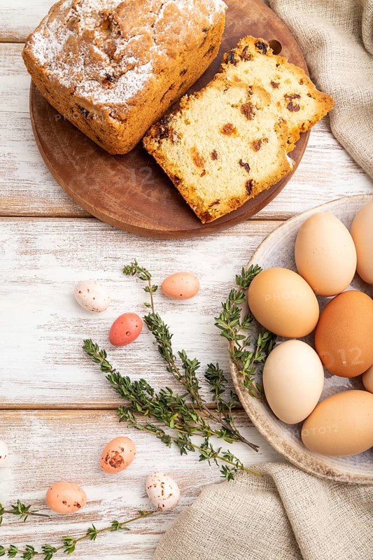 Homemade easter pie with raisins and eggs on plate on a white wooden background and linen textile. top view, flat lay, close up
