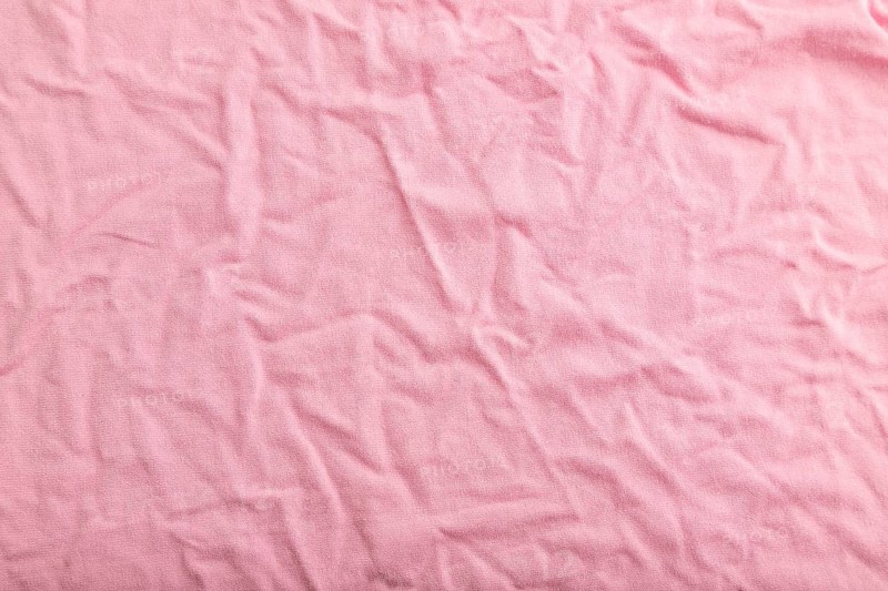 Fragment of pink cotton tissue. Top view, flat lay, natural textile background and texture