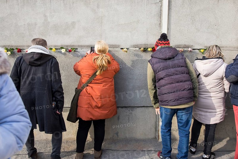Visitors look through a gap in the Wall at the central commemorative event at the Berlin Wall Memorial to mark the 35th anniversary of the fall of the Wall in Berlin, 9 November 2024