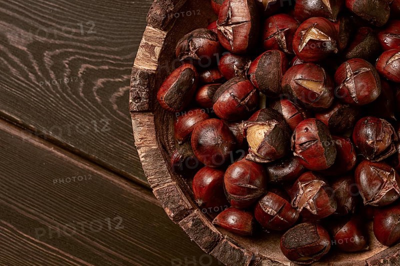 Roasted chestnuts, in a wooden plate, top view, homemade, no people