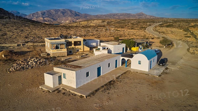 Small Mediterranean-style houses in a rural desert landscape, blue and white Agios Theodoros chapel, drone shot, evening light, Paralia Agios Theodoros, Agios Theodoros Beach, south-west coast, Karpathos, Dodecanese, Greek Islands, Greece, Europe