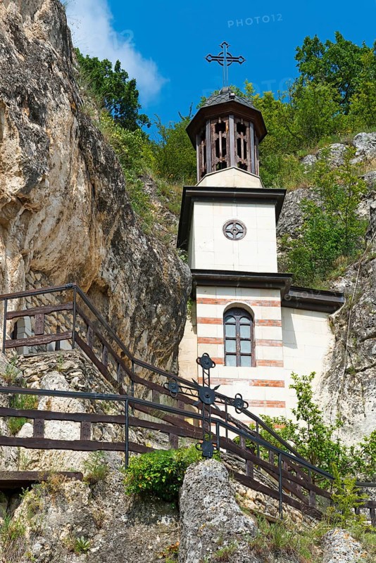 Bell tower with clock and cross surrounded by stairs and blue sky, Bulgarian Orthodox cave monastery, rock monastery, Basarbowski monastery, Basarbowski, Basarbovo, Basarbovo, Russe, Rhodope Mountains, Bulgaria, Europe