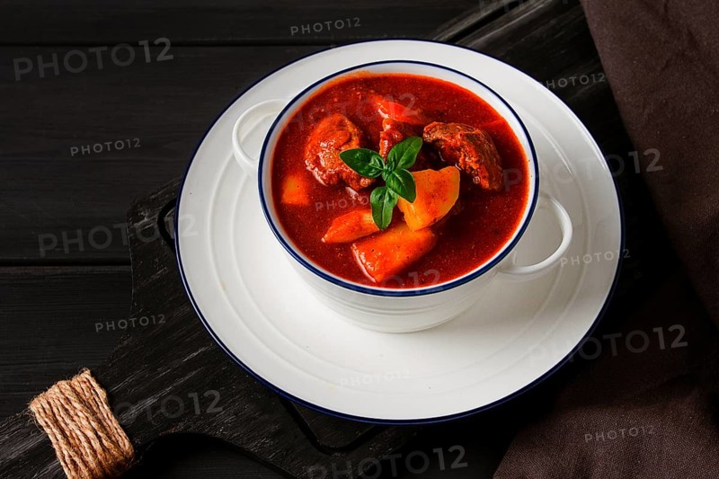 Stew with potatoes, in tomato sauce, with spices and herbs, close-up, no people, on a black background