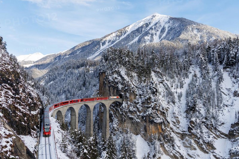Rhaetian Railway train at the famous Landwasser Viaduct on the Albula railway Stadler Rail passenger train in the Alps in Filisur, Switzerland, Europe