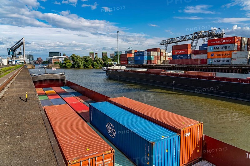 New customs yard building complex, the Gehry buildings, at the media harbour, behind it the city gate building, harbour facilities, container ship at the terminal of DCH Düsseldorfer Container Hafen GmbH Düsseldorf, North Rhine-Westphalia, Germany, Europe