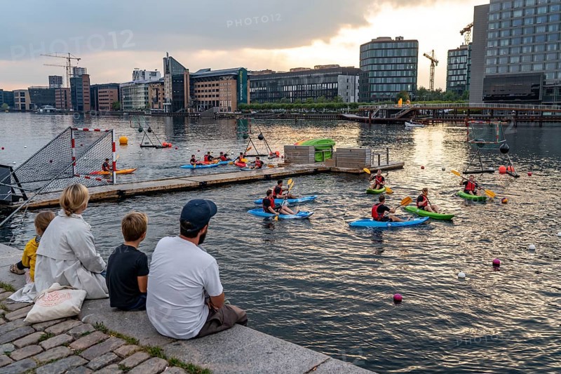 Summer evening in Copenhagen, at the harbour, Islands Brygge, people celebrating, eating, drinking, relaxing at the harbour shore, kayak polo, Denmark, Europe