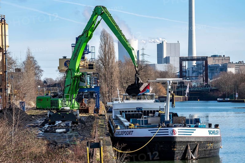 WHE Westthafen Wanne, coal for power plants is transferred from a Belgian cargo ship coming from Antwerp to freight wagons, on the Rhine-Herne Canal, in the background the STEAG combined heat and power plant Herne, North Rhine-Westphalia, Germany, Europe
