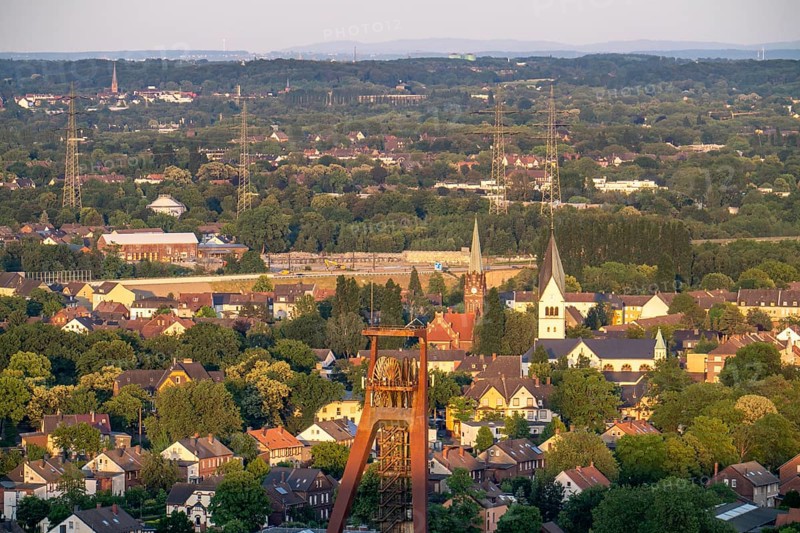 Residential estate in the countryside, terraced houses, multi-family houses, parts of former mining estate in Recklinghausen-Hochlarmark, headframe of former Recklinghausen colliery, Shaft IV, St Michael's Church, right and Reformation Church, left, North Rhine-Westphalia, Germany, Europe