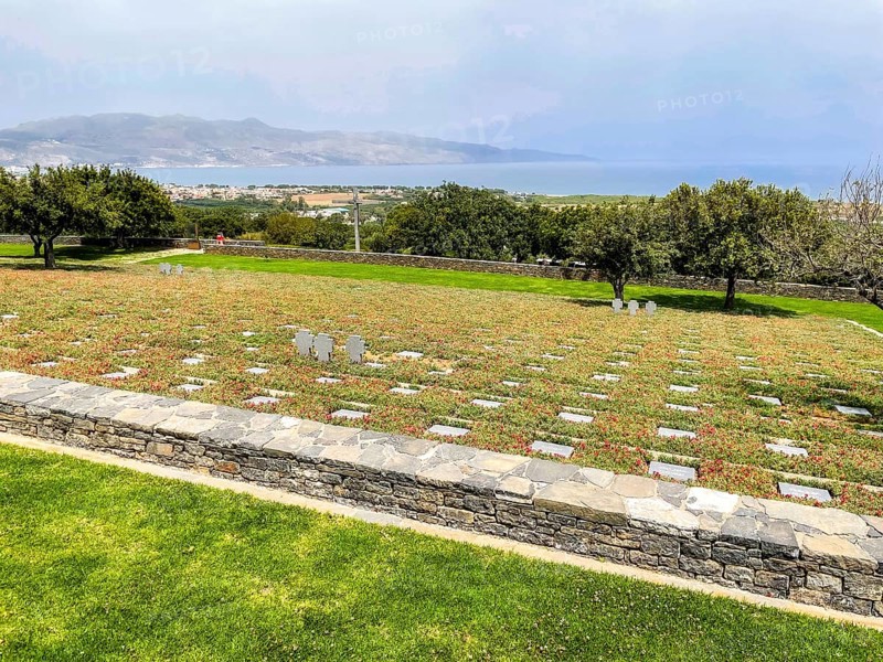 View over rows of graves with gravestones Grave slabs on part of German military cemetery inaugurated in 1974 by the German War Graves Commission on former battlefield in World War II heavily contested hill height 107, in the background Aegean Sea Aegean Sea Mediterranean Sea on the north coast of Crete, Maleme, Crete, Greece, Europe