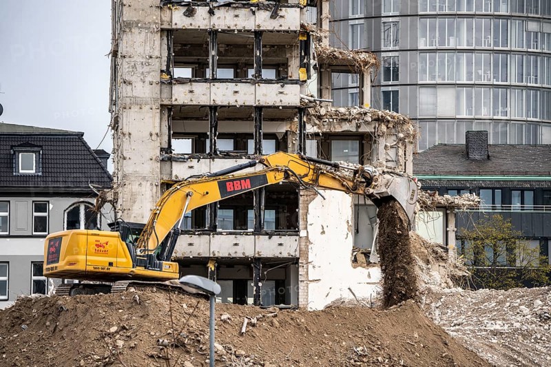 Demolition of the former RWE building complex, in the city centre, on the A40 motorway in Essen, excavator working on the piles of rubble, in the background the RWE Tower, North Rhine-Westphalia, Germany, Europe