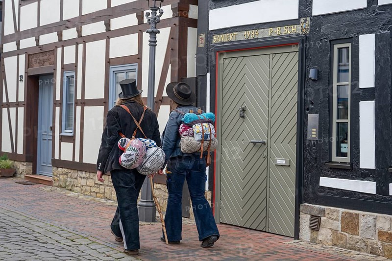 Travelling craftsmen on the road through half-timbered alley Rinteln Germany