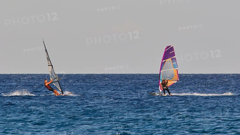 Two windsurfers navigating over the blue sea under clear skies, windsurfing, Meltemi windsurfing spot, Devils Bay, Paralia Vatha, Vatha Beach, south-east coast, Karpathos, Dodecanese, Greek Islands, Greece, Europe