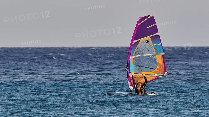 A windsurfer with a shining sail enjoys the calm of the sea, windsurfer, Meltemi windsurfing spot, Devils Bay, Paralia Vatha, Vatha Beach, southeast coast, Karpathos, Dodecanese, Greek Islands, Greece, Europe