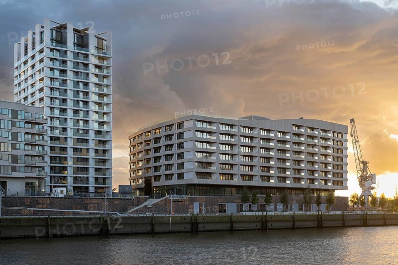Modern residential building on Strandkai, Historic crane, Dramatic clouds, Überseequartier, Hafencity, Hamburg, Germany, Europe