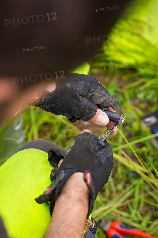 Close-up of hands in gloves working on a cable, focus on detail work, fibre optic assembly, Calw district, Black Forest, Germany, Europe