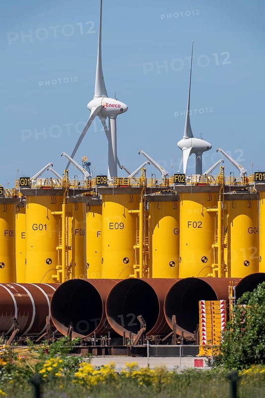 Transhipment centre for offshore wind turbines, which are transported here by the manufacturer and then shipped by special ships to the construction sites of the wind farms in the North Sea, here, yellow, so-called Transition Pieces Jackets, which are mounted on the monopile foundations driven into the seabed, on which the actual wind turbine is then mounted, in the port area of Vlissingen-Oost, Netherlands