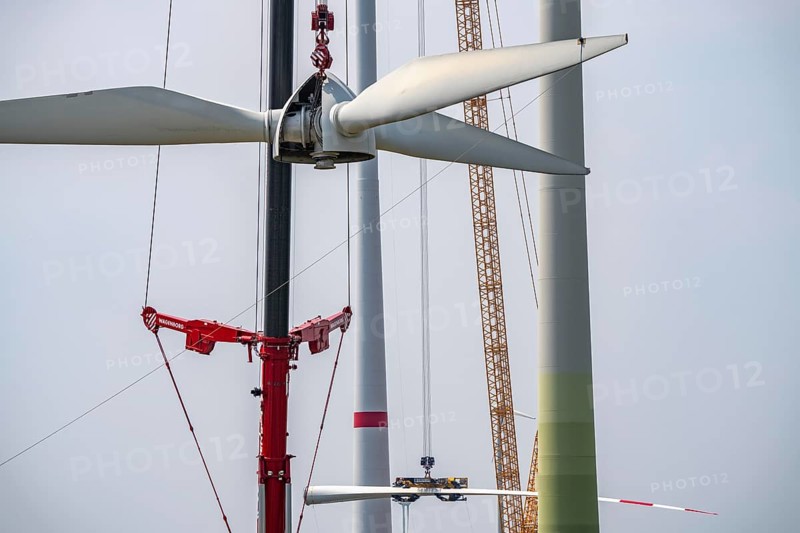 Dismantling of a wind power plant in a wind farm near Issum, 9 older wind turbines from the manufacturer Enercon (model series E-58), front, blades being dismantled, were in operation for over two decades, will be replaced by a total of four Enercon E-160 turbines, rear, assembly of the first blade, with a total output of 22 megawatts, Lower Rhine, North Rhine-Westphalia, Germany, Europe