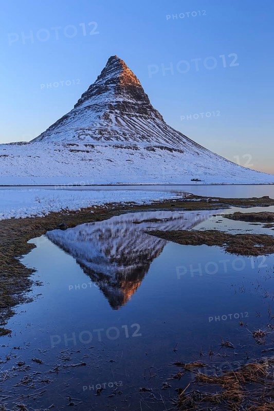 Pointed mountain reflected in fjord at low tide, snow, winter, morning light, Kirkjufell, Snaefellsnes, Iceland, Europe
