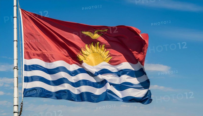 The flag of Kiribati, Polynesia, flutters in the wind, isolated against a blue sky