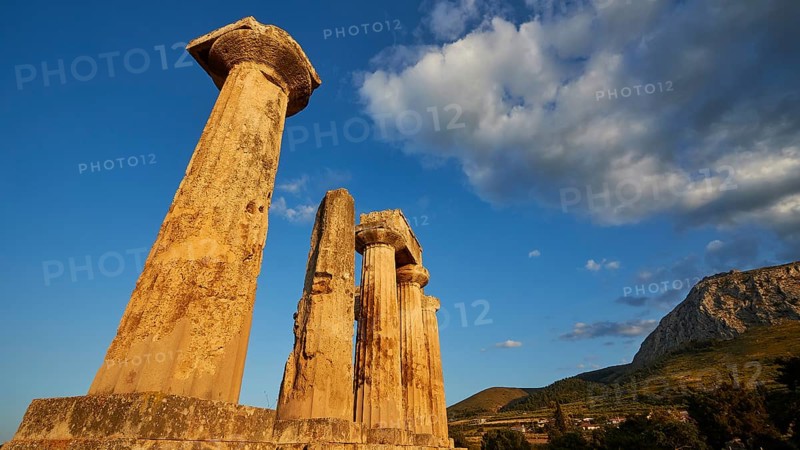 Archaic Temple of Apollo, Doric Columns, Ruins of ancient columns against a vivid blue sky with warm sunlight, Archaeological site, Archea Korinthos, Corinth, Peloponnese, Greece, Europe