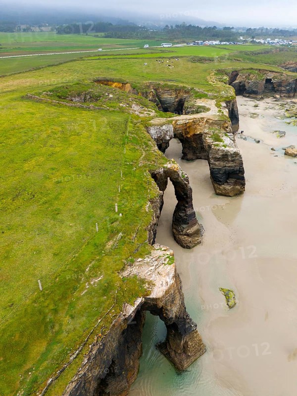 Steep cliffs with several prominent rock arches and lush green meadows reaching down to the sea, aerial view, Praia das Catedrais, Playa de las Catedrales, Cathedral beach, As Catedrais beach, Cantabrian Sea, Ribadeo, Galicia, Galicia, Spain, Europe