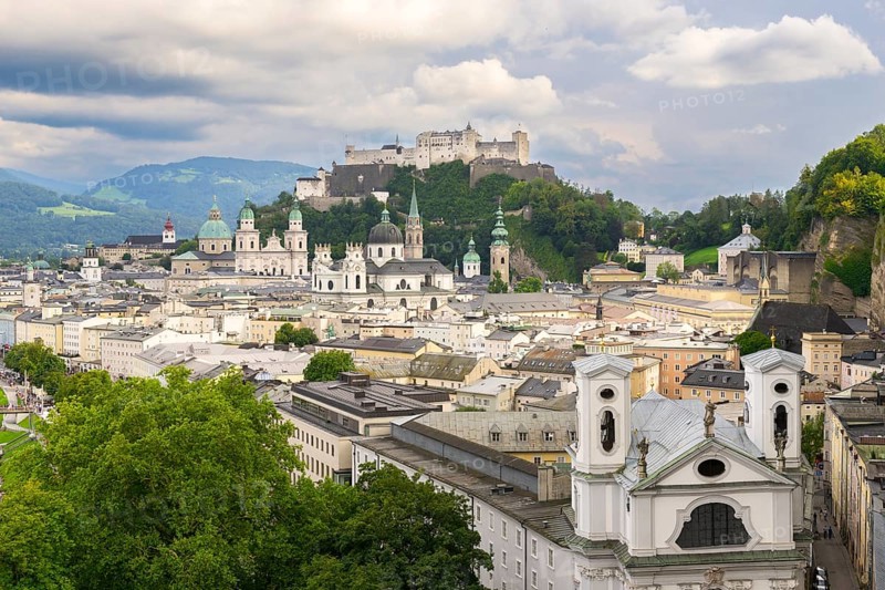 View of Salzburg with Hohensalzburg Fortress in the background and the historic city centre in the foreground, surrounded by mountains under a cloudy sky, Salzburg, Salzburger Land, Austria, Europe