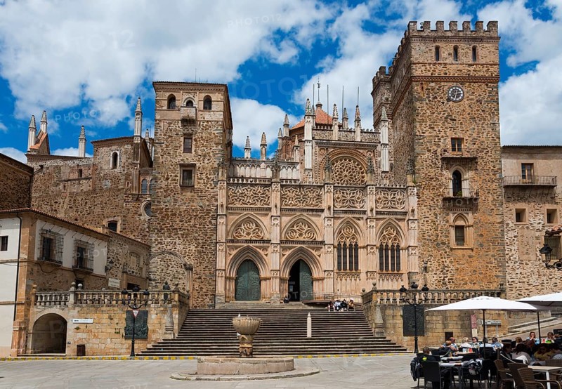 Historisches steinernes Gebäude auf einem Platz unter einem bewölkten Himmel, Wallfahrtskirche und Kloster, Real Monasterio de Nuestra Señora de Guadalupe, Guadalupe, Provinz Cáceres, Caceres, Extremadura, Spanien