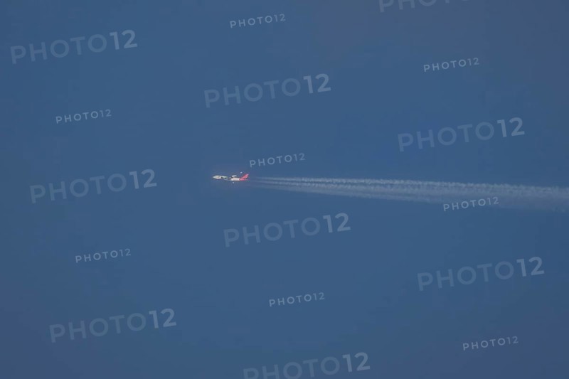 Boeing 747 jumbo jet aircraft in flight with a contrail or vapour trail in the sky, England, United Kingdom, Europe
