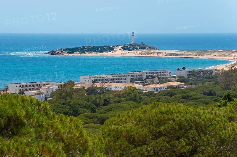 Island with lighthouse and white buildings, surrounded by green forest and blue sea, view of Los Caños de Meca, La Breña y Marismas del Barbate Natural Park, Faro de Trafalgar, Cape Trafalgar, province of Cádiz, Costa de la Luz, Andalusia, Spain, Europe